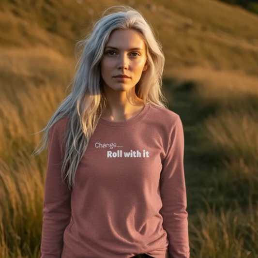 Woman wearing a pink long-sleeve shirt with text standing in a grassy field.