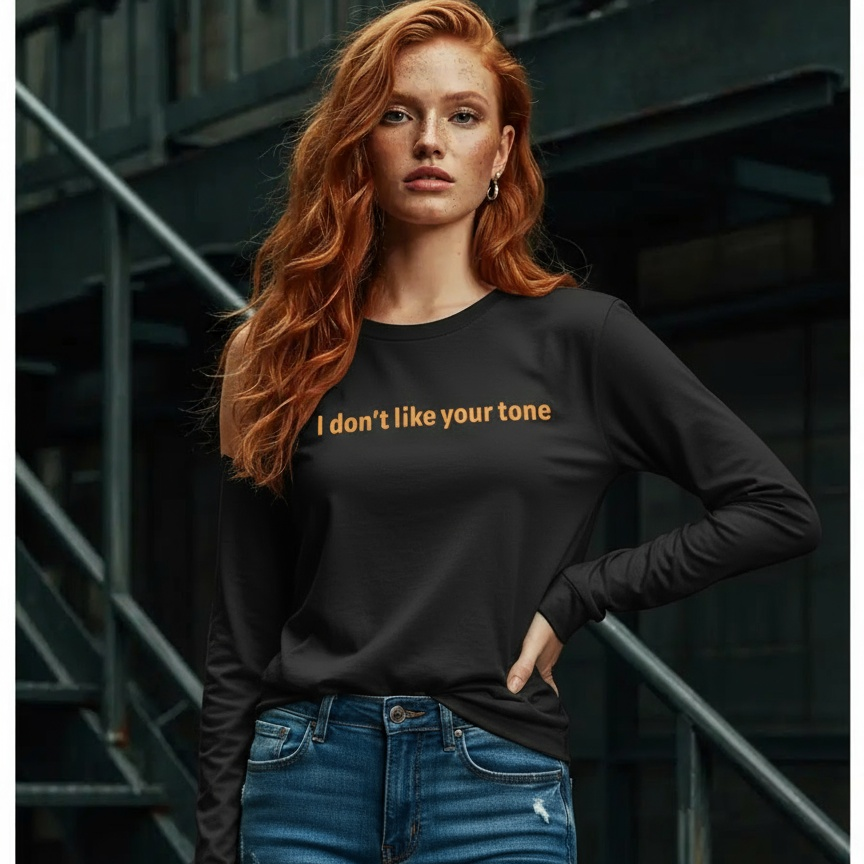 Woman wearing a black long-sleeve shirt with text and blue jeans standing on stairs.